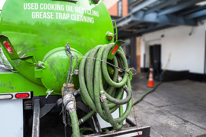 a technician pumping a grease trap in a commercial building in Loxahatchee FL